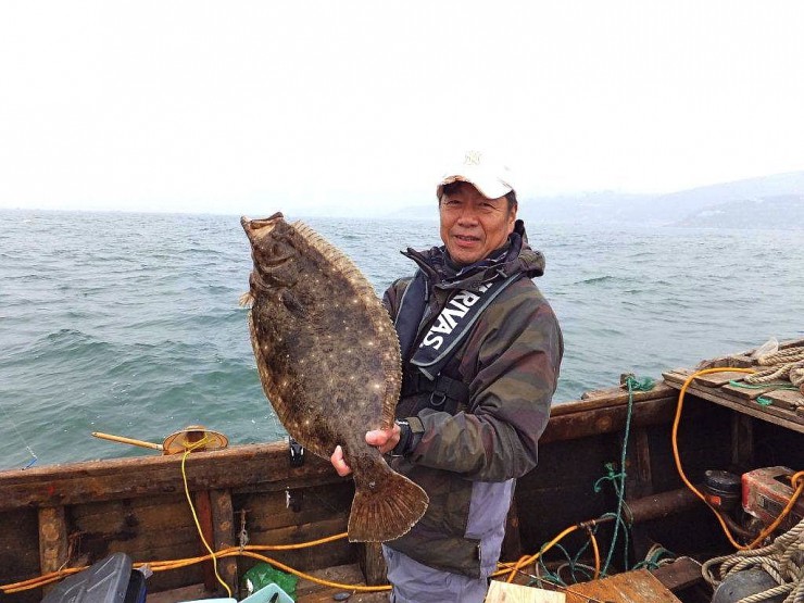 巨大ヒラメを釣り上げ満足顔の杉原さん