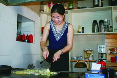 鉄板の前で自ら腕を振るう王孝君さん