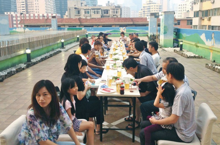 気持ちの良い屋上テラスで生ビールやバーベキューを楽しむ大連錦華銀座酒店の入居者たち